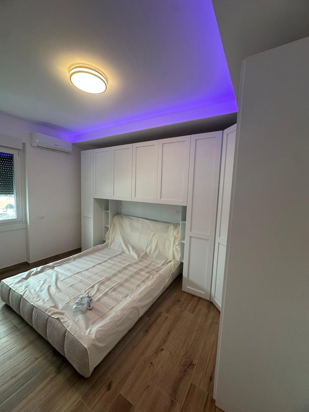 Camera da letto moderna con luce LED calda a soffitto